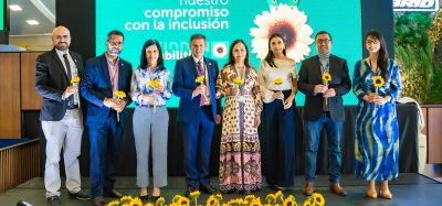 A group of Mariscal Sucre International Airport's executive board holding sunflowers with an image of the programme in the background.
