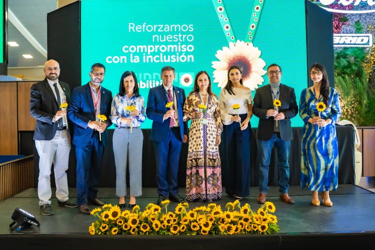 A group of Mariscal Sucre International Airport's executive board holding sunflowers with an image of the programme in the background.