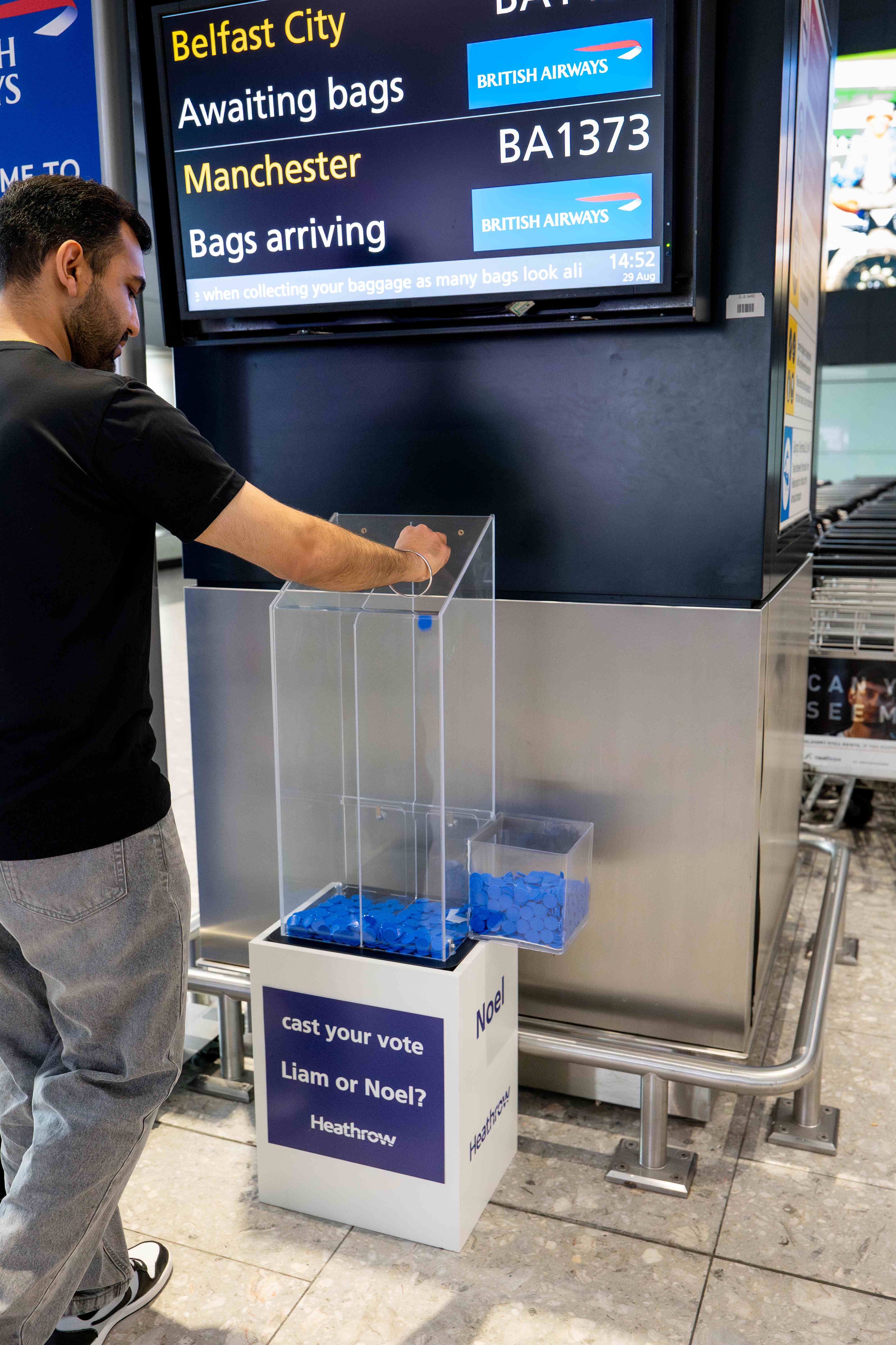 Man casting vote for who is his Oasis favourite brother at London Heathrow Airport
