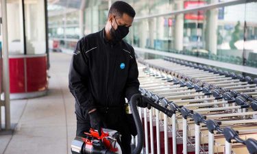 A staff member at Toronto Pearson Airport disinfects baggage carts in between use with a disinfecting fogging machine