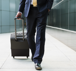 Business traveller with suitcase at airport