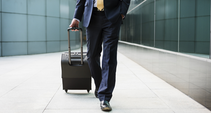 Business traveller with suitcase at airport